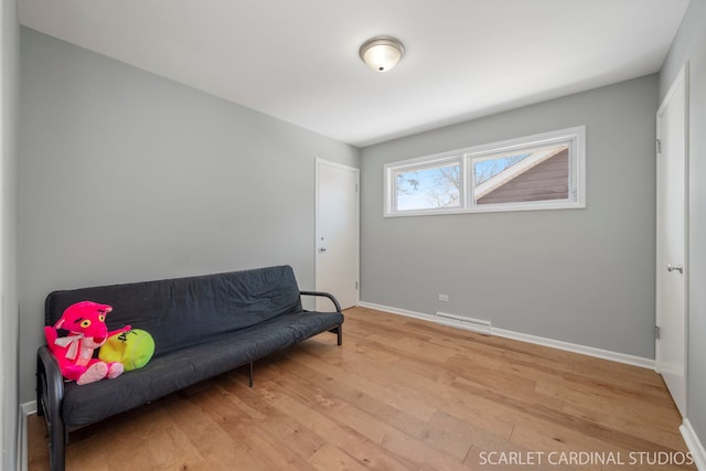 sitting room featuring visible vents, light wood-style flooring, and baseboards