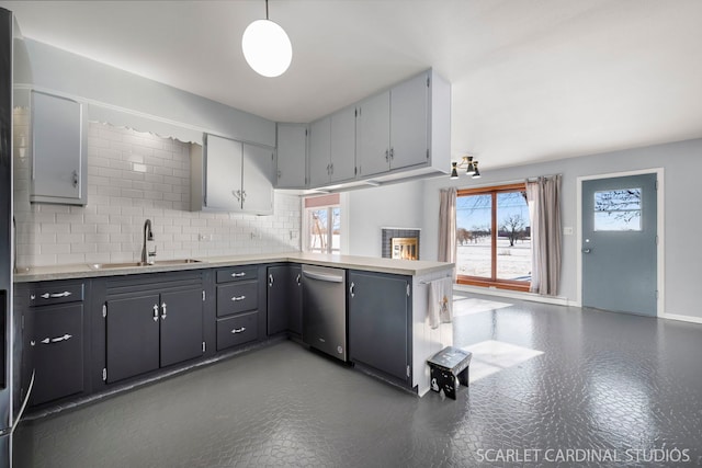 kitchen featuring light countertops, a peninsula, decorative light fixtures, and gray cabinetry