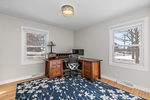 office featuring visible vents, baseboards, and wood finished floors