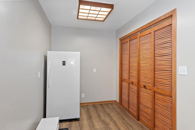 hallway with wood finished floors and baseboards