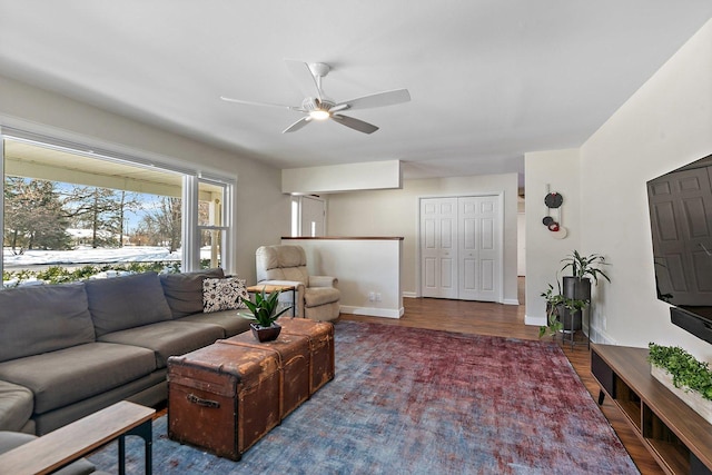 living room with baseboards, dark wood finished floors, and a ceiling fan