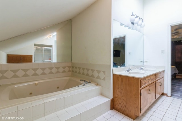 ensuite bathroom with vaulted ceiling, double vanity, a sink, and tile patterned flooring