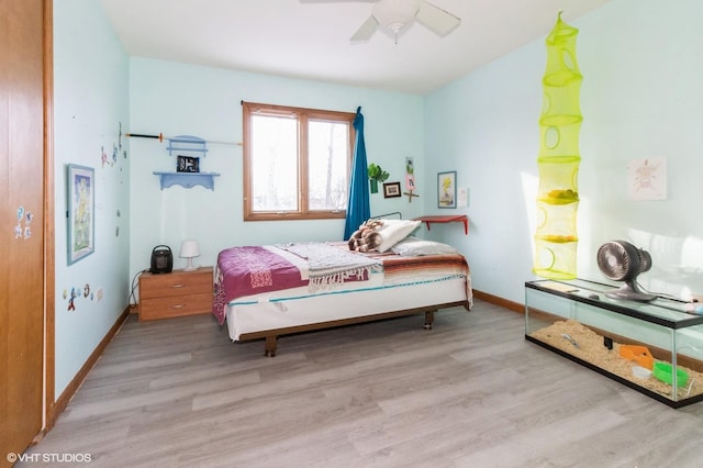 bedroom with light wood finished floors, baseboards, and a ceiling fan