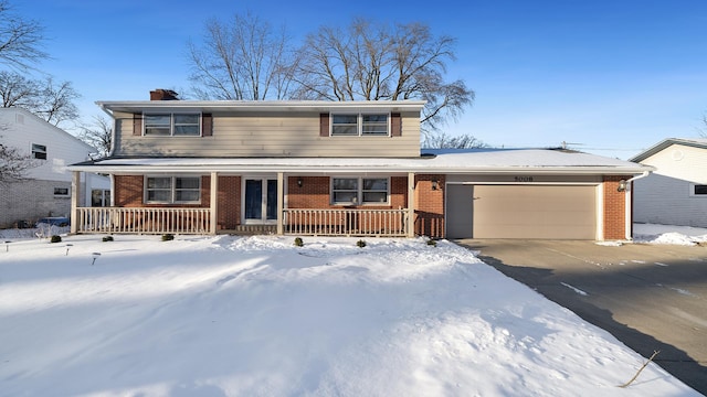 traditional home with covered porch, brick siding, an attached garage, and concrete driveway