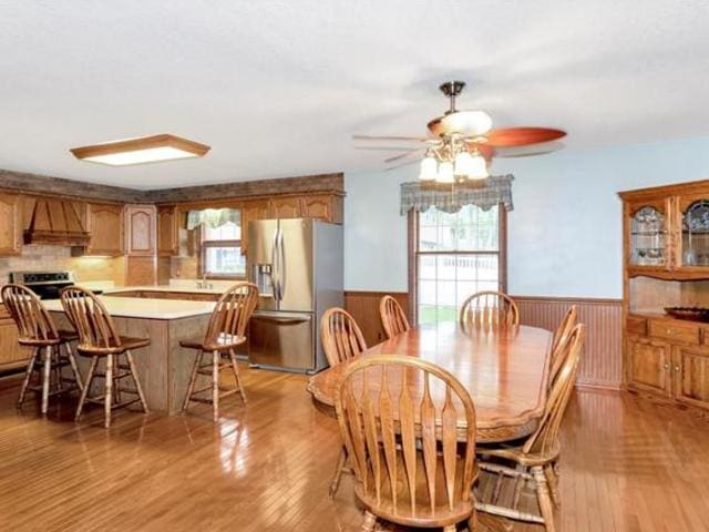 330 Fox Trl, Bourbonnais, IL 60914 - dining area with wainscoting, light wood-style floors, ceiling fan, and wooden walls