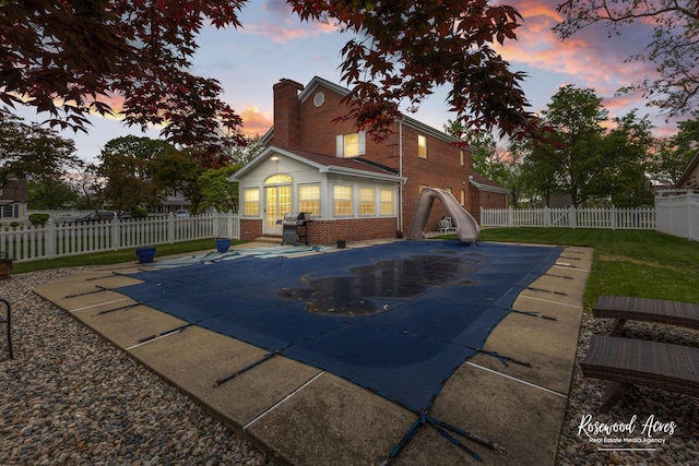 330 Fox Trl, Bourbonnais, IL 60914 - pool at dusk with a water slide, a patio, and a fenced backyard