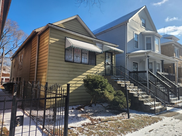 view of front of house with stairway and fence