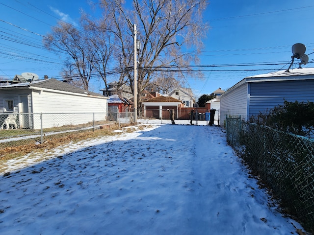 snowy yard featuring an outbuilding and fence