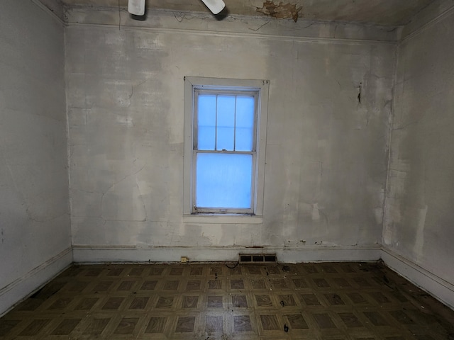 spare room featuring dark floors and visible vents