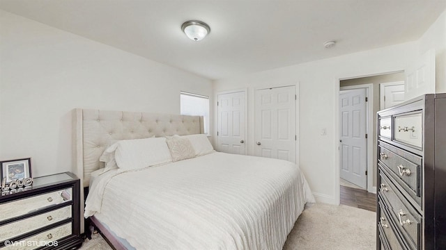 bedroom with two closets and baseboards