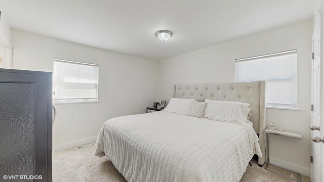 carpeted bedroom featuring visible vents and baseboards