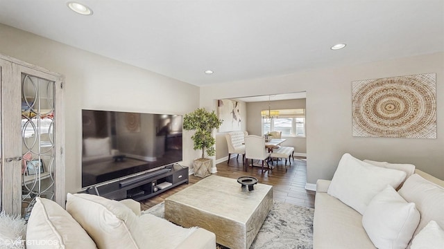 living area featuring an inviting chandelier, baseboards, wood finished floors, and recessed lighting