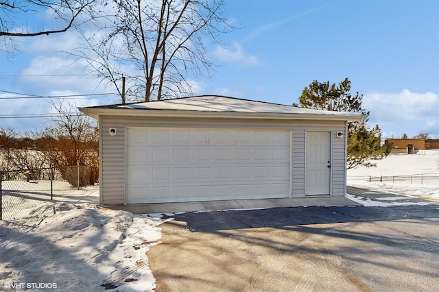 detached garage featuring fence