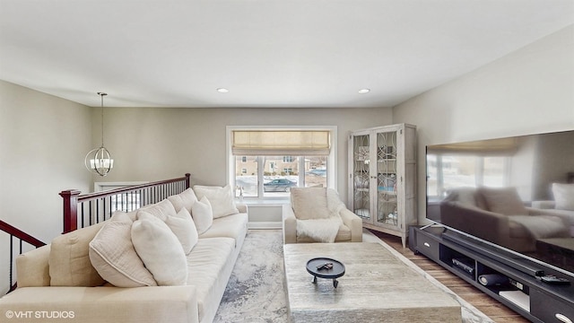 living room featuring recessed lighting, a notable chandelier, and wood finished floors