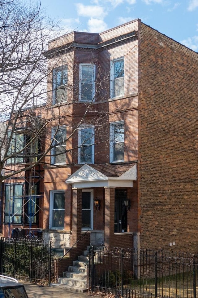 view of front of house featuring a fenced front yard and brick siding