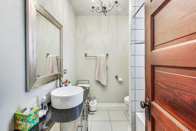 full bathroom featuring baseboards, toilet, tile patterned flooring, vanity, and a chandelier