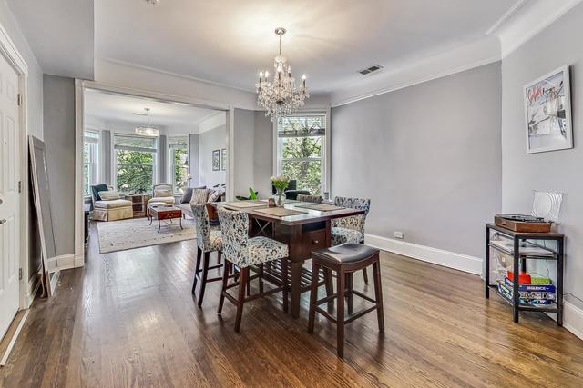 dining room featuring dark wood-style floors, ornamental molding, a wealth of natural light, and an inviting chandelier