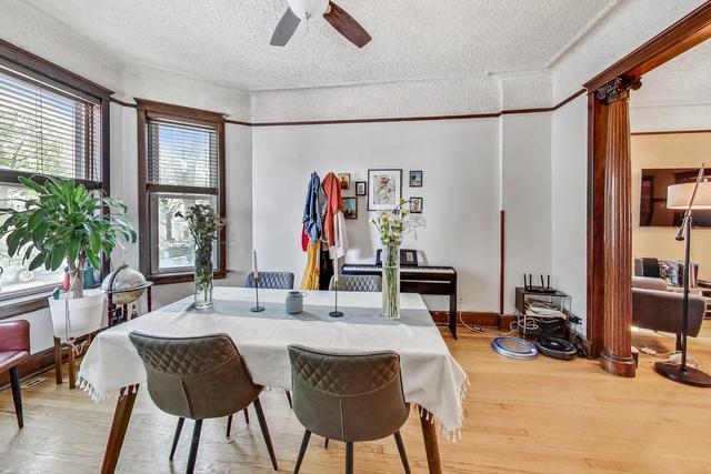 dining area featuring a ceiling fan, decorative columns, a textured ceiling, and wood finished floors