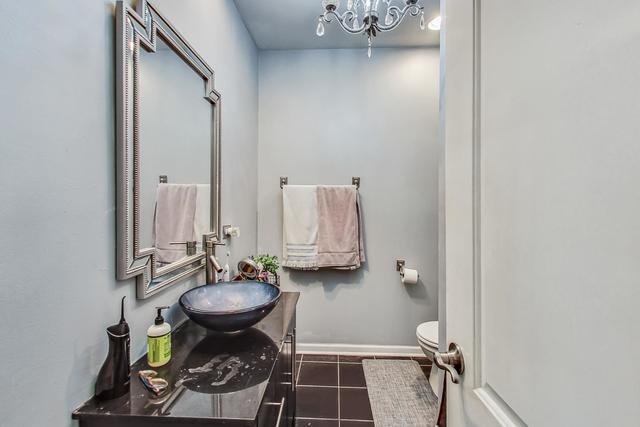 bathroom featuring toilet, tile patterned flooring, vanity, and baseboards