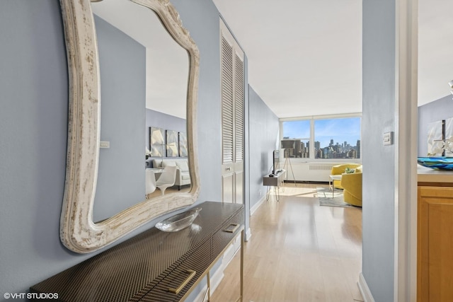 hallway featuring baseboards and light wood-style floors