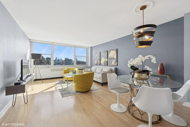 living room with light wood-style floors, radiator, and baseboards