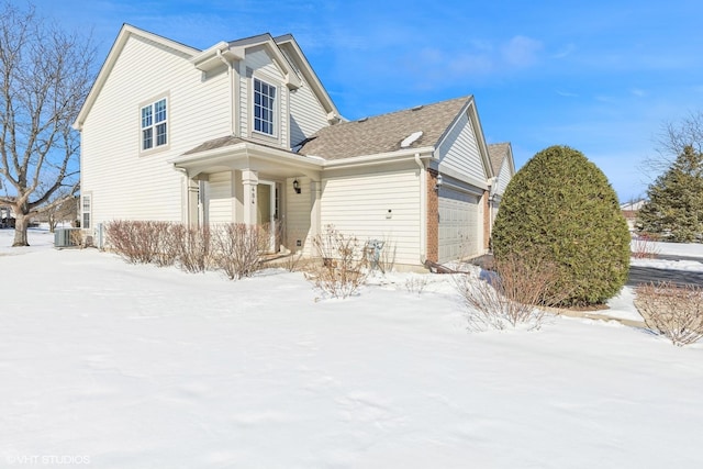 view of front of house featuring an attached garage and central air condition unit