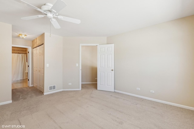 unfurnished bedroom with baseboards, visible vents, light colored carpet, ceiling fan, and a closet