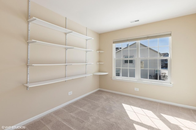 carpeted empty room featuring visible vents and baseboards