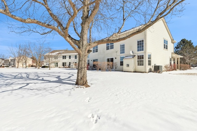 snow covered back of property with central air condition unit