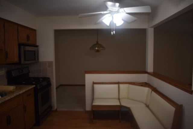 10600 Lynn Dr, Orland Park, IL 60467 - kitchen with brown cabinetry, decorative backsplash, appliances with stainless steel finishes, wood finished floors, and light countertops