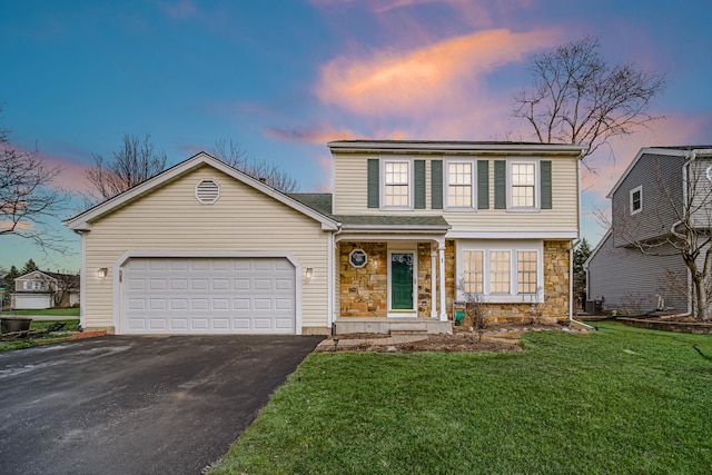 view of front of property with driveway, stone siding, an attached garage, and a front lawn