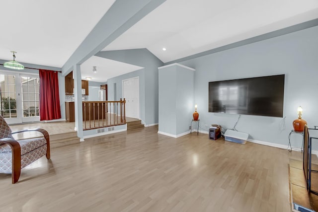 living room with lofted ceiling, baseboards, and wood finished floors