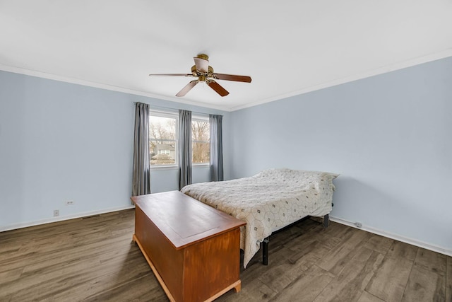 bedroom featuring dark wood-type flooring, crown molding, baseboards, and a ceiling fan