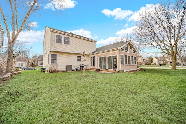 back of house featuring a sunroom, central AC, and a yard