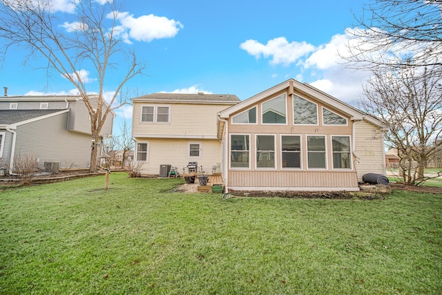 rear view of property with a lawn and central air condition unit