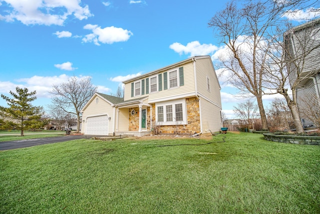 colonial-style house with a front yard, stone siding, driveway, and an attached garage