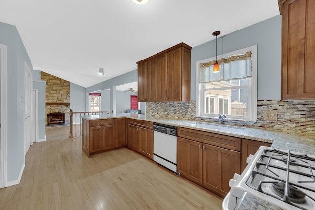 kitchen with a peninsula, white appliances, a sink, and a wealth of natural light