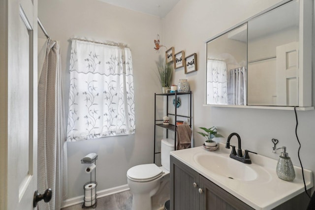 bathroom with baseboards, toilet, a shower with curtain, wood finished floors, and vanity