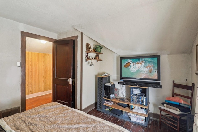 bedroom featuring lofted ceiling, a textured ceiling, baseboards, and dark wood-type flooring