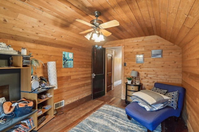 living area with wooden ceiling, wooden walls, visible vents, vaulted ceiling, and dark wood-style floors