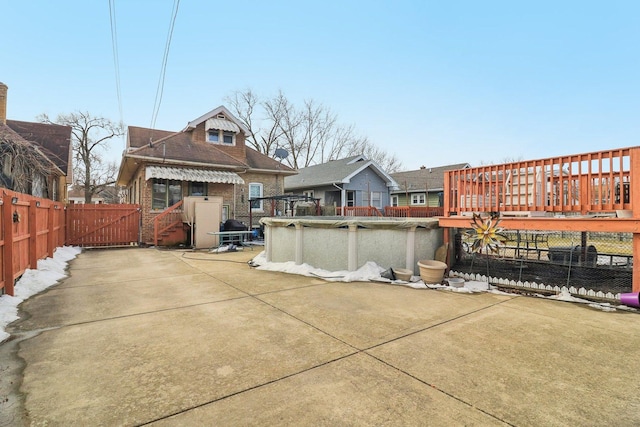 exterior space with a covered pool, a gate, fence, and a wooden deck