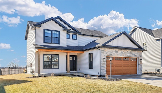 view of front of house featuring fence, a garage, stone siding, driveway, and a front lawn