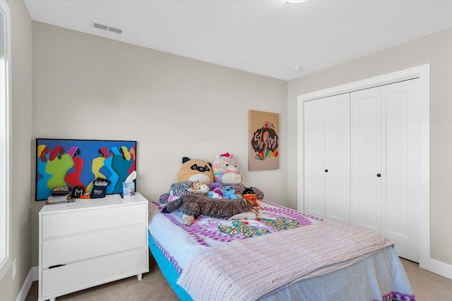 carpeted bedroom with a closet, visible vents, and baseboards