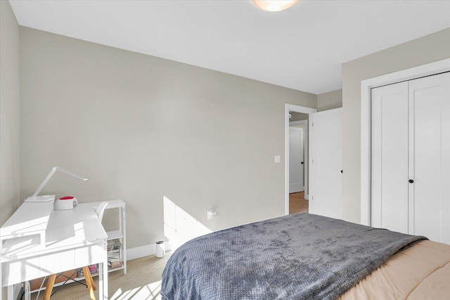 bedroom with carpet, a closet, and baseboards