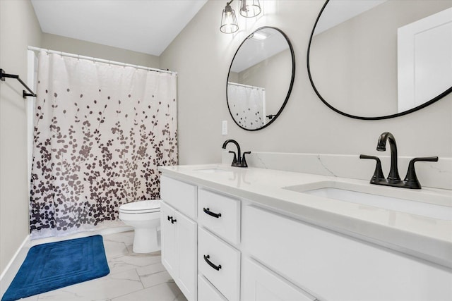 bathroom with marble finish floor, double vanity, a sink, and toilet