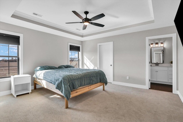 carpeted bedroom with a raised ceiling, visible vents, baseboards, and multiple windows