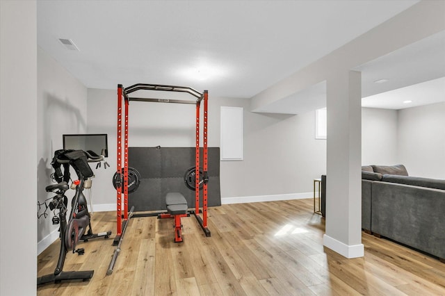 workout room featuring wood-type flooring, visible vents, and baseboards