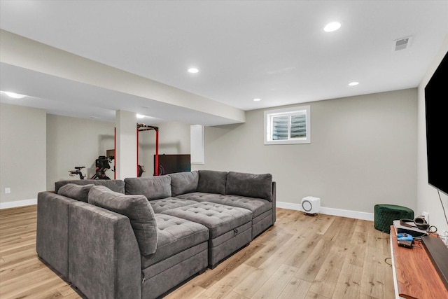 living room with light wood-style flooring, visible vents, and baseboards