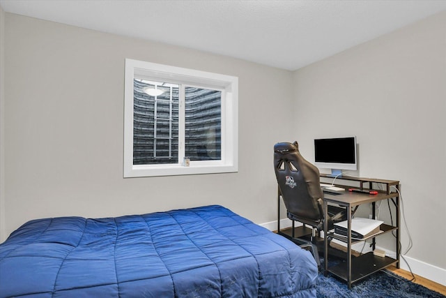 bedroom featuring wood finished floors and baseboards