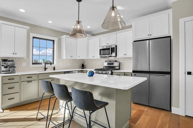 kitchen featuring a center island, light countertops, appliances with stainless steel finishes, a sink, and light wood-type flooring